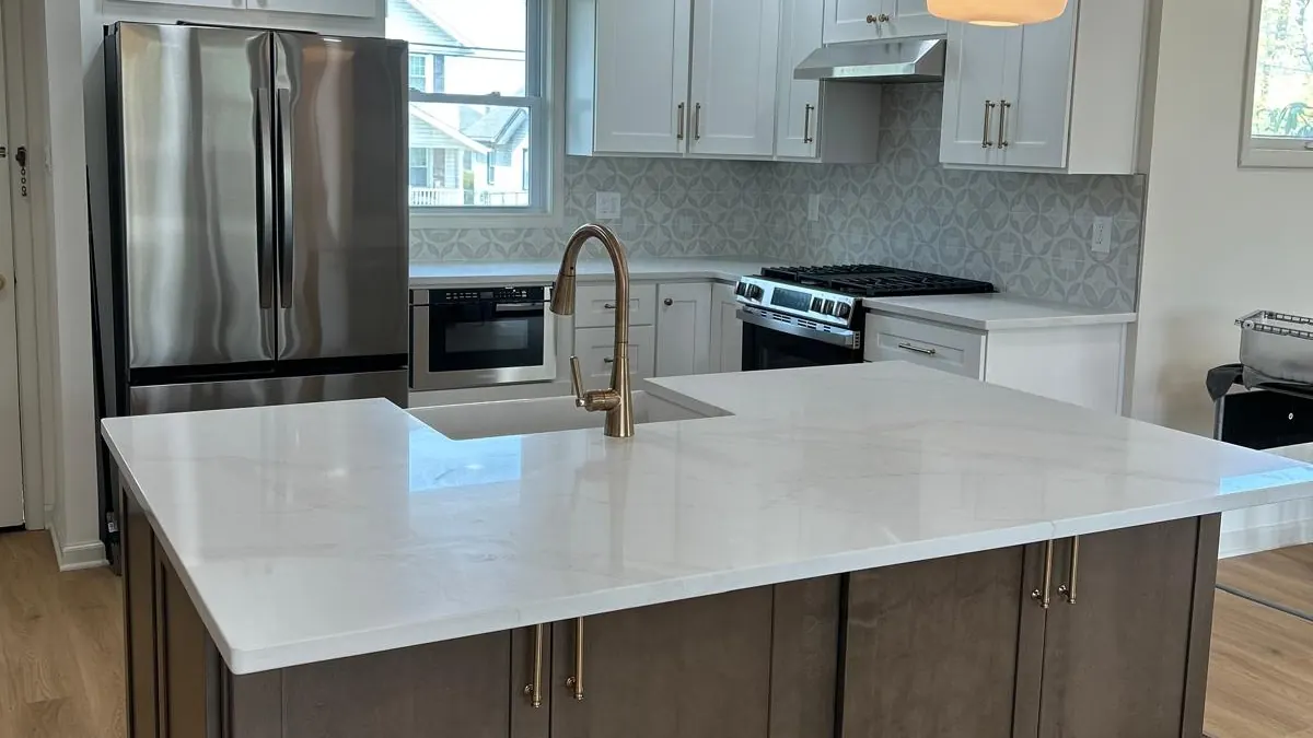 Kitchen with a gray island, a white countertop, and two pendant lights
