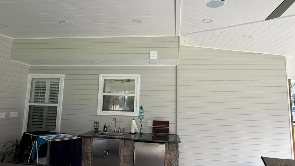 Bright room with white shiplap walls and a stone wet bar